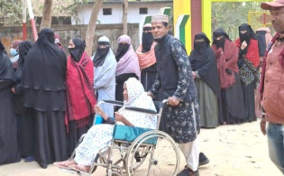 হুইলচেয়ারে বসেও নিজে ভোট দিতে এসেছেন বৃদ্ধা আবজান